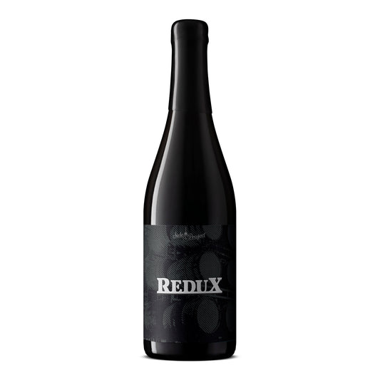 Black beer bottle with 'Redux' label on a white background